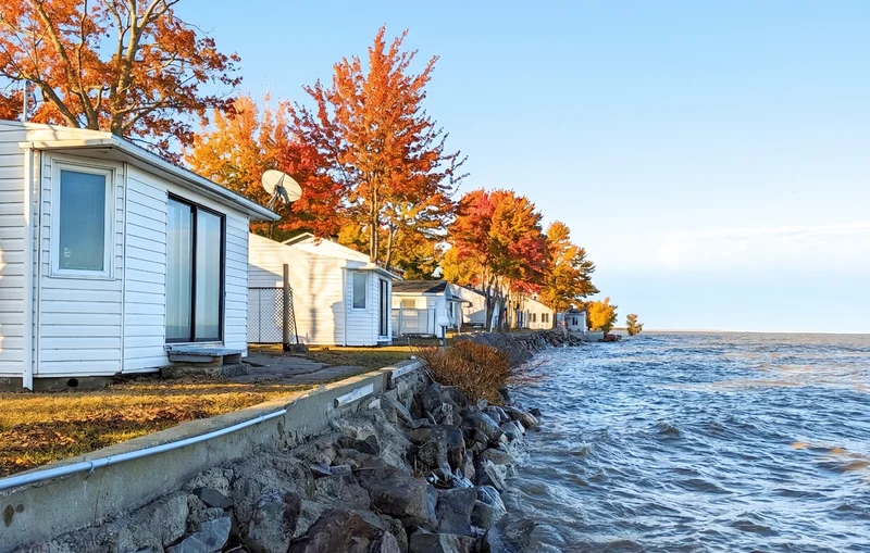 Les chalets alignés sur la rive en automne